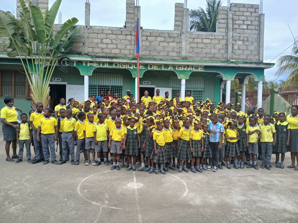 Teacher with students in classroom in Cap-Haïtien